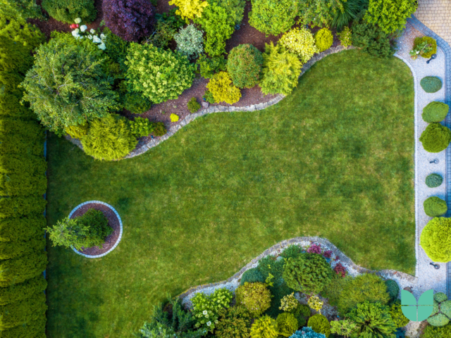 An Aerial photography of a garden with grass, plants, trees and patio